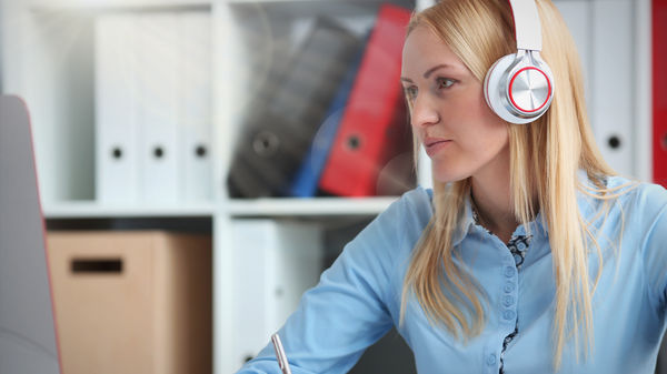 Online-Seminar Damit mit Headset vor Bildschirm folgt einem Webinar