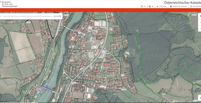 Kartenansicht eines österreichischen Ortes aus dem Kataster: dicht bebautes Siedlungsgebiet mit Straßennetz, angrenzende Felder, rechts ein Waldgebiet und links fließt ein Fluss durch die Siedlung.