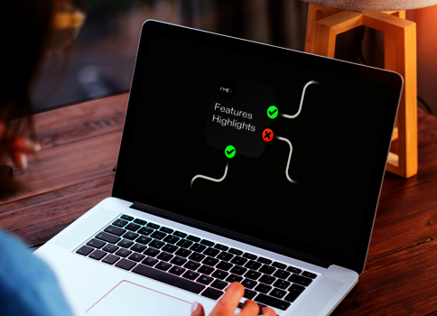 Eine Person sitzt an einem Holztisch und arbeitet an einem Laptop. Auf dem Bildschirm ist eine dunkle Oberfläche mit einer Grafik und der Überschrift "Features Highlights" sowie grünen Häkchen.