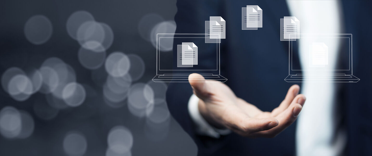 Eine Person im Anzug streckt die Hand aus, über der Hand schweben transparente Dokumente oder Dateien, Symbol für digitalen Dateiaustausch oder Cloud-Übertragung.