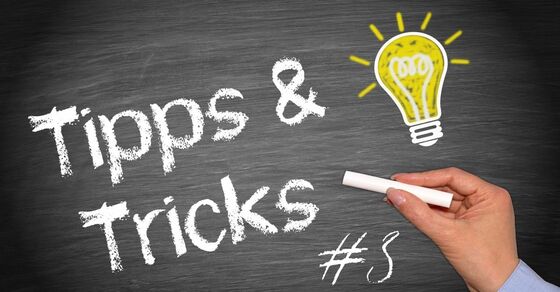Eine Kreidetafel mit der Aufschrift "Tipps & Tricks". Eine Hand hält Kreide und schreibt, daneben leuchtet eine gelbe Glühbirne als Symbol für Ideen.