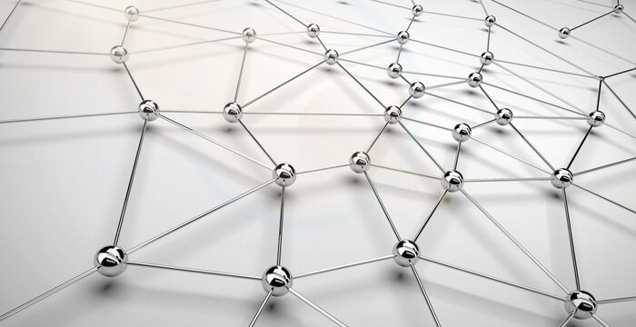 Ein dreidimensionales Netz aus silbernen Metallkugeln, die durch dünne Stäbe verbunden sind, bildet ein geometrisches Gitter.